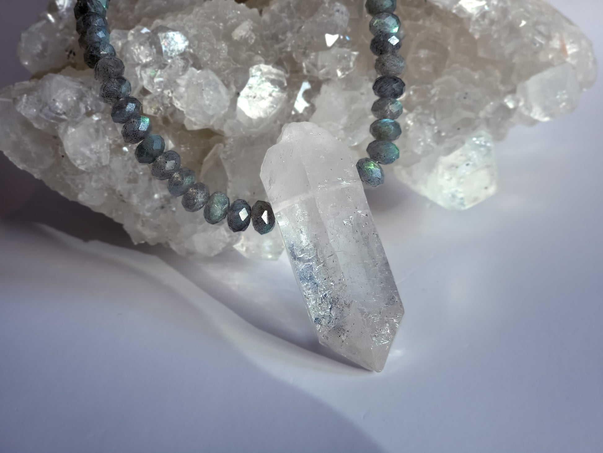 Crystal Quartz Necklace on top of raw crystal cluster